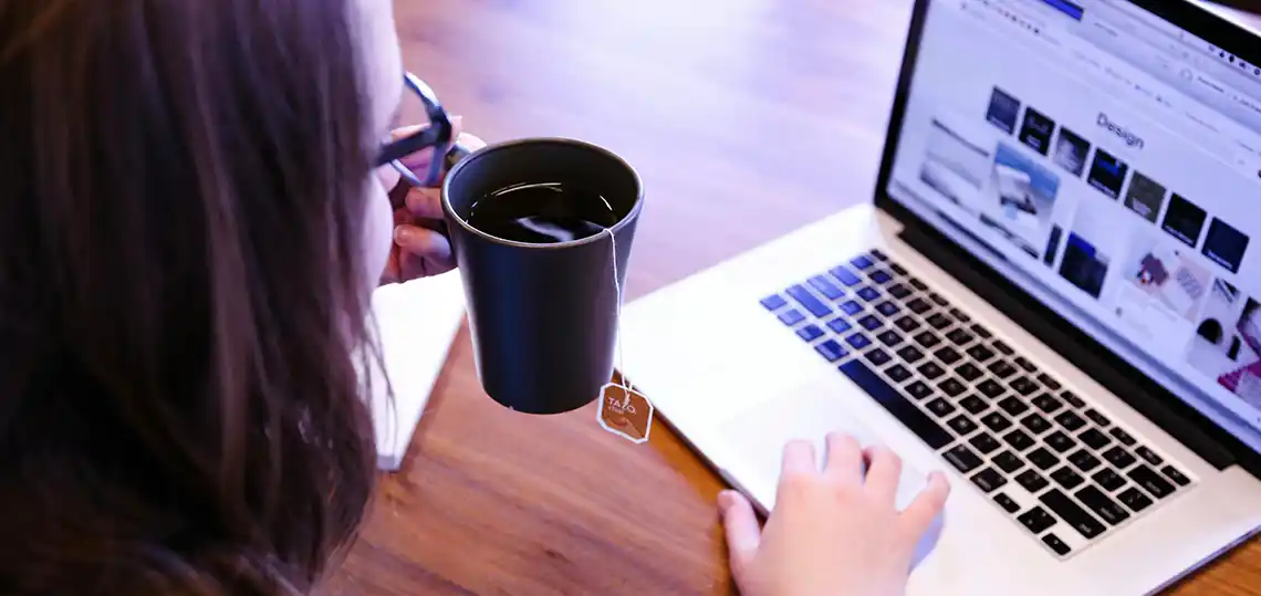 Woman in front of laptop computer with coffee