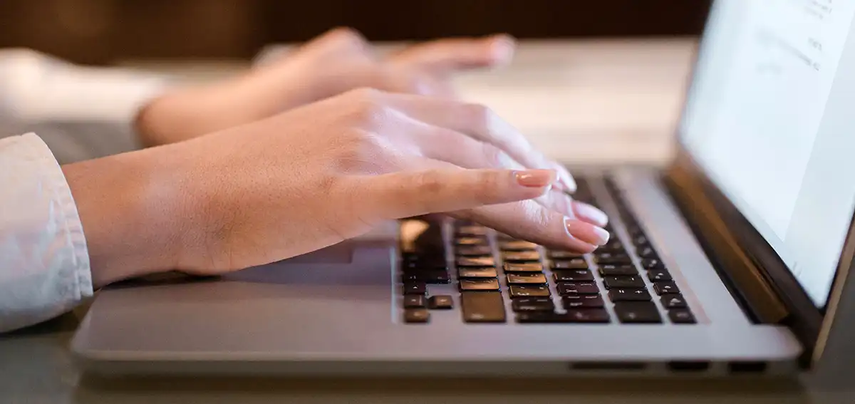 Female fingers typing on a laptop