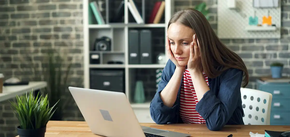 Woman concerned looking at her laptop