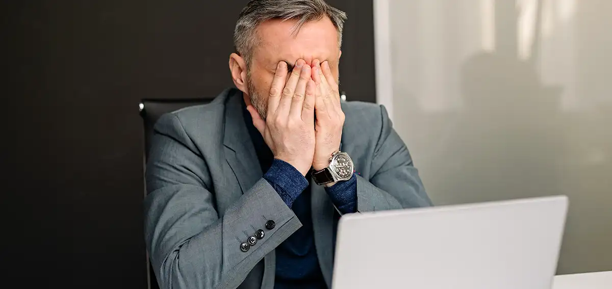 Man frustrated in front on laptop